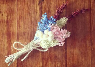 Pastel, pink and light blue flower boutonniere, made with broom, blooms, phalaris and lavender.